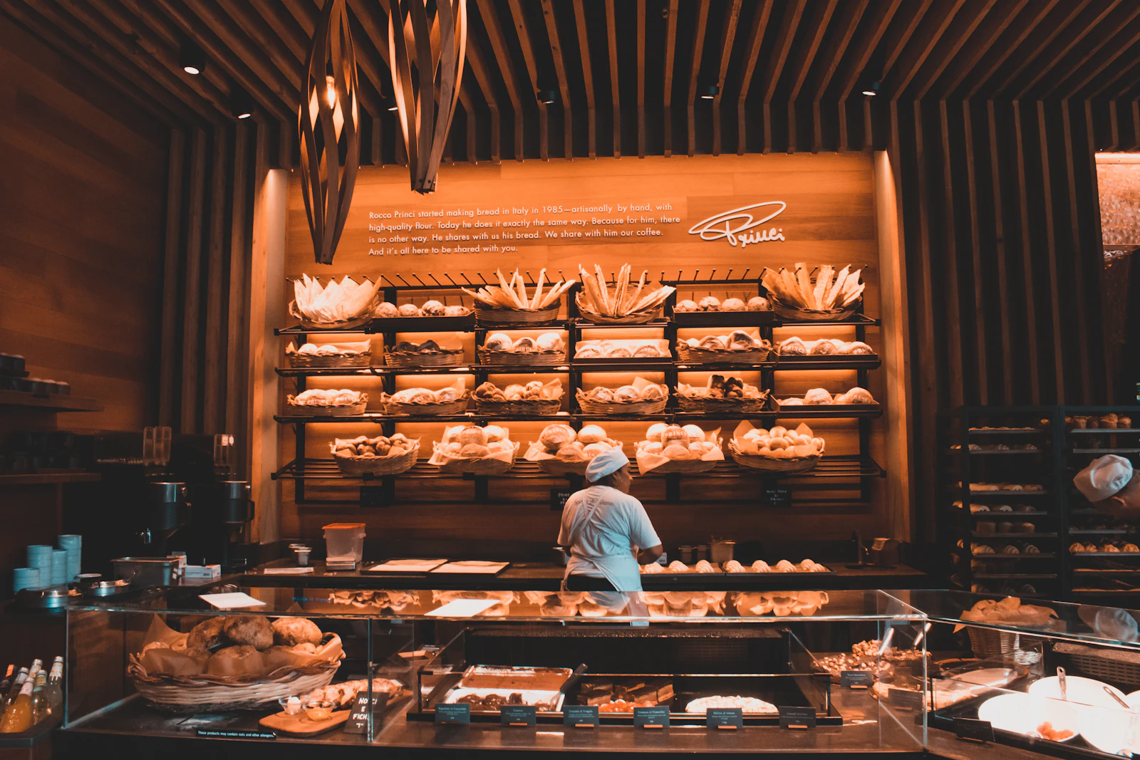 The warm, wood-lined bakery interior with shelves of bread