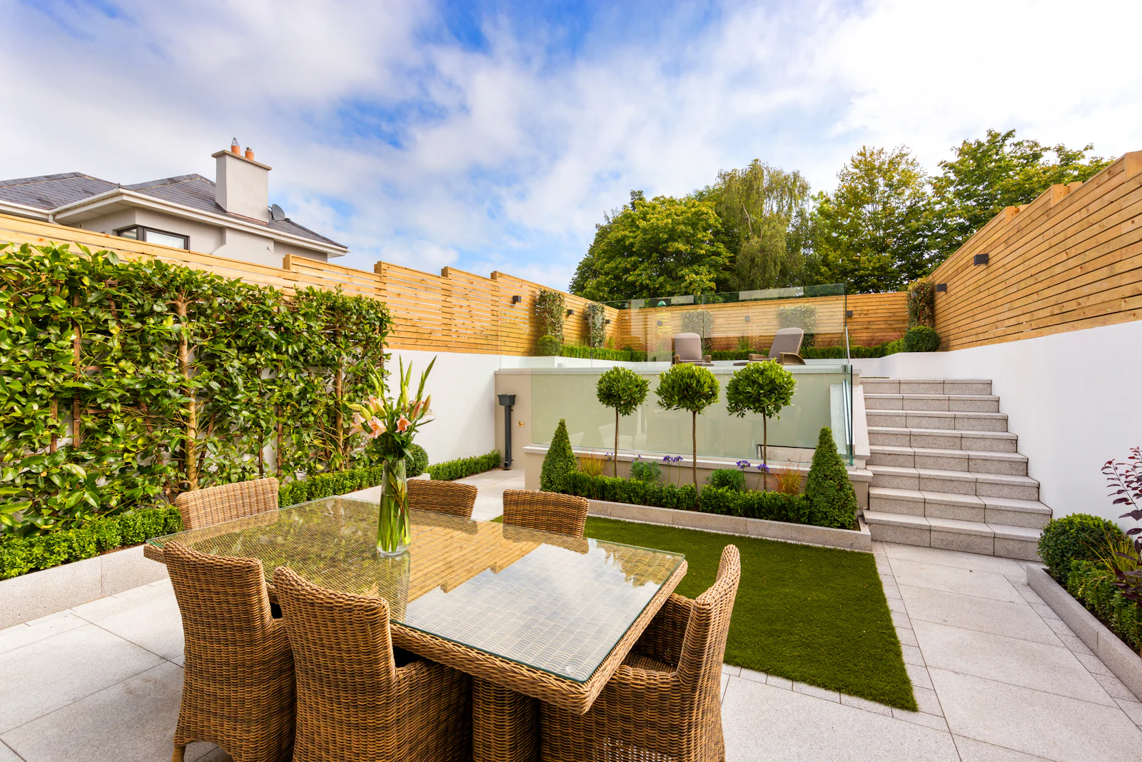 A stone patio surrounded by hedges